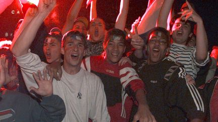 Des jeunes français expriment leur joie après la victoire de la France face&nbsp;à la Croatie en demi-finale de Coupe du monde, le&nbsp;8 juillet 1998. (JACK GUEZ / AFP)