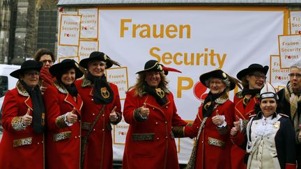 Des femmes costumées devant un "point sécurité" pour les femmes pour le carnaval de Cologne (Allemagne) le 3 févrizer 2016.&nbsp; (WOLFGANG RATTAY / REUTERS)