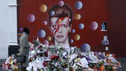 Hommages devant une peinture murale de David Bowie à Brixton, un quartier de Londres dont la star est originaire, le 12 janvier 2016. (STEFAN WERMUTH / REUTERS)