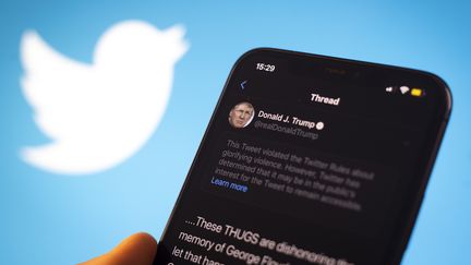 L'avertissement affiché par le réseau social Twitter au-dessus d'un tweet de Donald Trump, publié le 29 mai 2020, prévenant que le message&nbsp;"viole les règles"&nbsp;du réseau social en&nbsp;"glorifiant la violence". (JAAP ARRIENS / NURPHOTO)