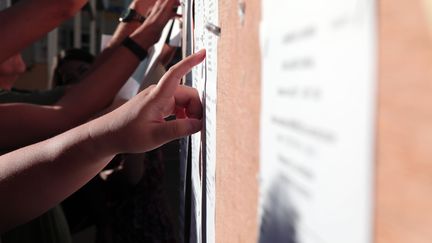 Des étudiants devant les résultats du bac. (RICHARD BOUHET / AFP)