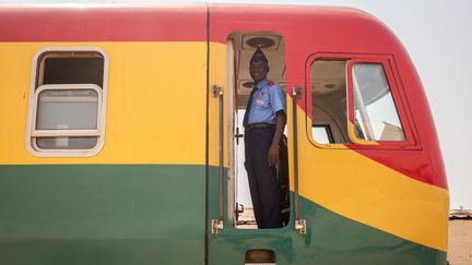 Un cheminot de la ligne de train reliant&nbsp;Accra, la capitale du Ghana, au port de Tema. Un train rouge-vert-jaune, les couleurs du pays. (RUTH MCDOWALL / AFP)