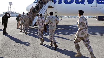 D'anciens rebelles ayant rejoint les rangs de l'arm&eacute;e libyenne, embarquent dans un avion pour l'Italie, le 9 janvier 2014. (MAHMUD TURKIA / AFP)