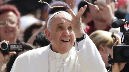 Le pape Fran&ccedil;ois tente d'attraper au vol un rosaire envoy&eacute; par un de ses fid&egrave;les sur la place Saint-Pierre &agrave; Rome (Vatican), le 5 juin 2013. (MAX ROSSI / REUTERS)