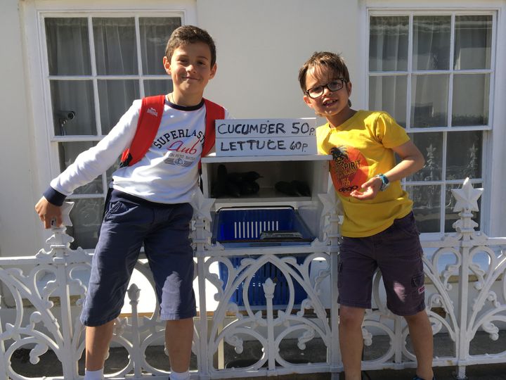 Edouard et Léo devant une "honesty box" (boite de l'honnêteté), postée devant une maison, une sorte de marché dans la rue, où l'on achète légumes, confitures... (INGRID POHU / RADIO FRANCE)