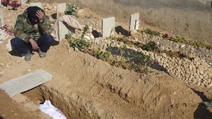 Un soldat de l'Arm&eacute;e syrienne libre se recueille sur la tombe de l'un de ses camarades, le 25 mars 2013 &agrave; Qusair (Syrie). (REUTERS)