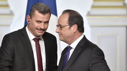 Hagi Hasan Brita, président du conseil local des quartiers d'Alep-Est (à gauche), en compagnie de François Hollande, à Paris, le 19 octobre 2016. (ALAIN JOCARD / AFP)