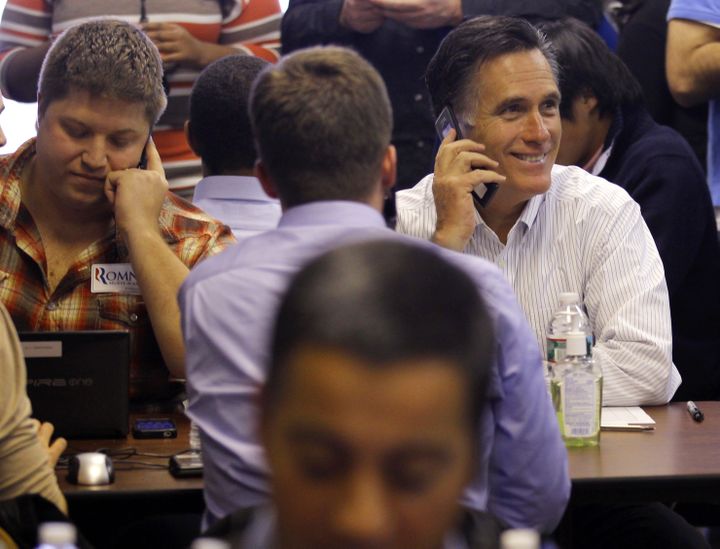 Mitt Romney t&eacute;l&eacute;phone &agrave; des &eacute;lecteurs ind&eacute;cis aux c&ocirc;t&eacute;s des volontaires de sa campagne, peu avant la primaire du New Hampshire, le 9 janvier 2012 &agrave; Manchester (Etats-Unis). (BRIAN SNYDER / REUTERS)