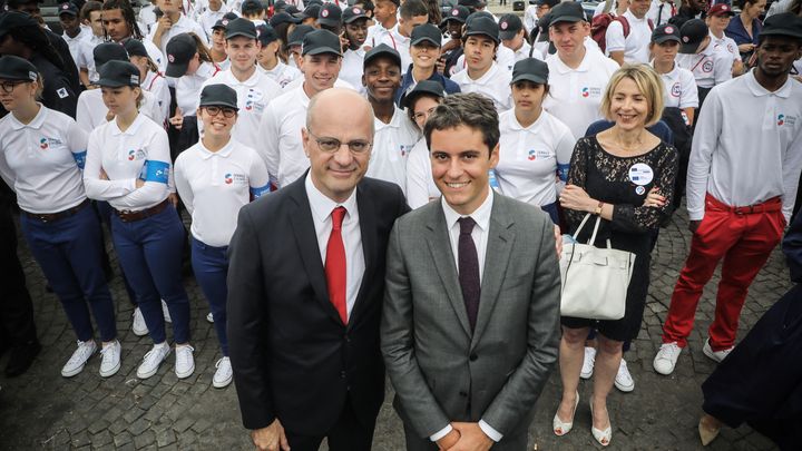 Gabriel Attal et Jean-Michel Blanquer posent avec des volontaires du Service national universel (SNU), à la fin du défilé militaire sur l'avenue des Champs-Elysées à Paris, le 14 juillet 2019. (LUDOVIC MARIN / POOL / AFP)