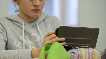 Une adolescente devant les réseaux sociaux sur sa tablette. (MAXPPP)