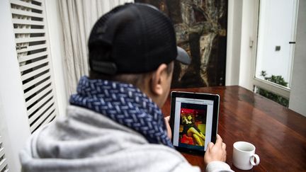 Chafik Lafrid, un Marocain âgé de 33 ans, regarde la photo de lui-même portant une robe et une perruque sur une tablette iPad dans la capitale, Rabat, le 18 janvier 2019.&nbsp; (FADEL SENNA / AFP)