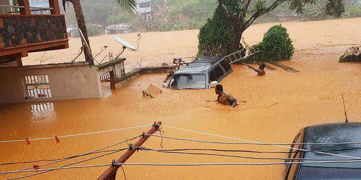 Un homme dans les rues inondées de Regent, près de la capitale de la Sierra Leone, Freetown le 14 août 2017  (STR / SOCIETY 4 CLIMATE CHANGE COMMUNICATION SIERRA LEONE / AFP)