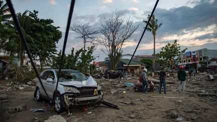 Une carcasse de voiture sur la plage de Palu, sur l'île de Sulawesi, le 29 septembre. Un séisme et un tsunami ont ravagés cette région d'Indonésie, vendredi 28 septembre. (BAY ISMOYO / AFP)