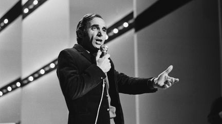 Charles Aznavour, sur un plateau de télévision, en 1968. (JACK BURLOT / SYGMA)