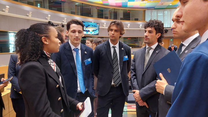 Lauriane (à gauche), une jeune étudiante qui joue le role de la présidente de la République française, entourée de ses homologues dans la salle du Conseil européen, en avril 2024 à Bruxelles. (ANGELIQUE BOUIN / RADIOFRANCE)