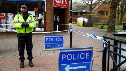 Un policier interdit l'accès au parc où l'ex-agent double Sergueï Skripal et sa fille Youlia ont été retrouvés empoisonnés neuf jours plus tôt,&nbsp;mardi 13 mars 2018 à Salisbury, dans le sud de l'Angleterre. (GEOFF CADDICK / AFP)