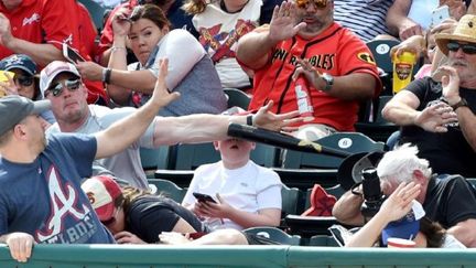 Un homme sauve un enfant d'une batte de baseball partie dans le public à pleine vitesse