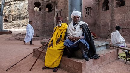 Le prêtre Mekonnen Fatne et un fidèle observent une église vieille de neuf siècles. Ils craignent de la voir détruite à tout moment. (EDUARDO SOTERAS / AFP)