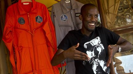 Mandla Maseko parle à un journaliste&nbsp;devant deux combinaisons de la NASA, à Pretoria, la capitale de l'Afrique du Sud, le 9 janvier 2014.&nbsp; (ALEXANDER JOE / AFP)