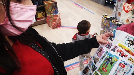 Une mère de famille consulte la liste de Noël de ses enfants dans un magasin de Brignoles (Var), en décembre 2021. (SOPHIE GLOTIN / RADIOFRANCE)