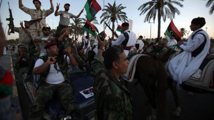 Des combattants du CNT acclament des membres de la tribu Warfalla, à Tripoli, le 9 septembre 2011 (AFP/PATRICK BAZ)