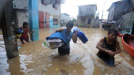 Des habitants d'un quartier est de Manille quittent la zone frappée par le typhon Nesat, le 27 septembre 2011. (NOEL CELIS / AFP)