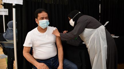 Une infirmière injecte une dose du vaccin d'AstraZeneca dans un centre de l'est de Londres (Royaume-Uni), le 14 avril 2021. (JUSTIN TALLIS / AFP)