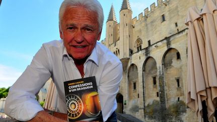 Didier Caulier posant avec son livre devant le Palais des Papes, théâtre d'un de ses braquages
 (PHOTOPQR/LA PROVENCE)