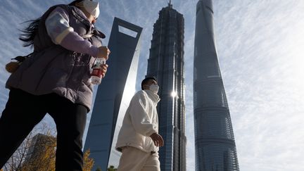 Deux passants dans le quartier financier de Lujiazui, à Shanghai (Chine) le 14 décembre 2022. Photo d'illustration (WANG GANG / MAXPPP)