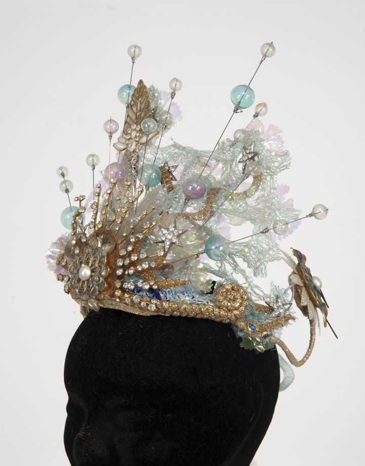 Circa 1997 Coiffe de bal figurant une couronne composée de strass à l’imitation brillants, de motifs en pâte de verre, de fleurs en rhodoïd, et de perles en verre soufflé multicolore, rehaussée de crin (éléments décollés). Portée au bal « Bleu » le 24 novembre 1997. 
 (Cornette de Saint Cyr)