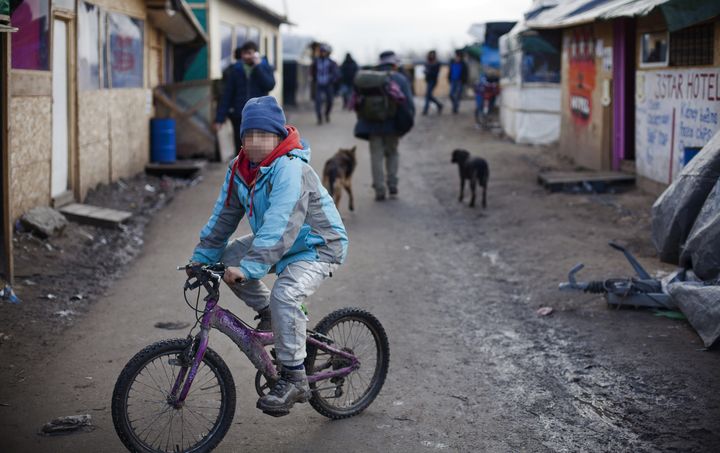 Jahangir, un orphelin afghan âgé de 10 ans,&nbsp;fait du vélo dans la jungle de Calais, le 23 février 2016. Ses deux parents sont morts durant&nbsp;la guerre. (MAXPPP)