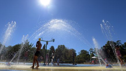 Des enfants se rafra&icirc;chissent dans une fontaine de Strasbourg (Bas-Rhin), le 1er ao&ucirc;t.&nbsp; (PATRICK HERTZOG / AFP)