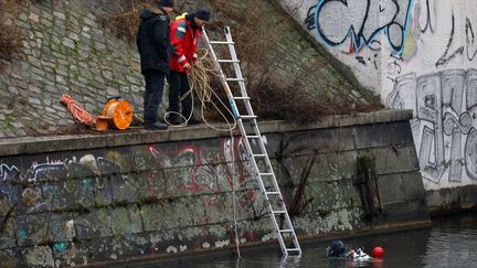 Des policiers allemands mènent une opération dans un canal de Berlin (Allemagne), le 25 décembre 2022, pour trouver des pièces volées dans un musée de Dresde. (DAVID GANNON / AFP)