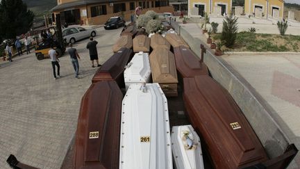 Un camion transportant les cercueils de migrants morts lors du naufrage de leur embarcation arrive au cimeti&egrave;re de Piano Gatta (Italie) avant leurs obs&egrave;ques, le 15 octobre 2013. (MARCELLO PATERNOSTRO / AFP)