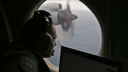 Un officier australien scrute l'oc&eacute;an &agrave; la recherche de d&eacute;bris, le 22 mars 2014, dans le sud de l'Oc&eacute;an indien. (ROB GRIFFITH / AFP)