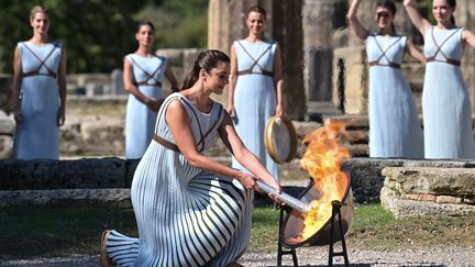 L'actrice grecque Xanthi Georgiou, jouant le rôle de la grande prêtresse, a allumé la torche lors de la cérémonie d'allumage de la flamme des Jeux olympiques d'hiver de Pékin 2022 sur le site archéologique d'Olympie, berceau des Jeux olympiques antiques, le 18 octobre 2021. (ARIS MESSINIS / AFP)