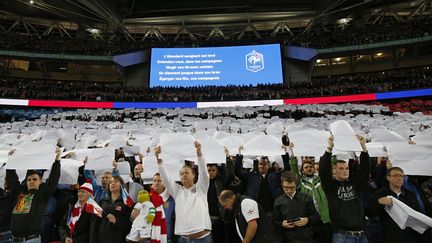 Des supporters anglais brandissent des papiers formant un drapeau français pendant "La Marseillaise" entonnée à Wembley, le 17 novembre 2015. (IAN KINGTON / AFP)