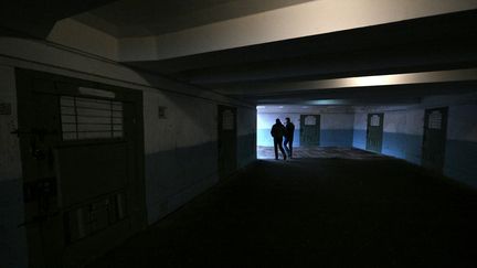 Un passage souterrain orné d'une fresque représentant un couloir de prison, dans le centre de Kiev (Ukraine), le 16 mars 2023. (SERGEI SUPINSKY / AFP)