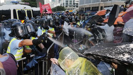 &nbsp; (La police de Hong Kong repousse des manifestants pro-démocratie dimanche en tirant plusieurs salves de gaz lacrymogène © REUTERS/Tyrone Siu)