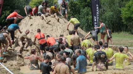 Des participants plong&eacute;s dans la boue lors de l'&eacute;preuve du "Mud Day" de Levens (Alpes-Maritimes), le 20 juin 2015. (MAXPPP)