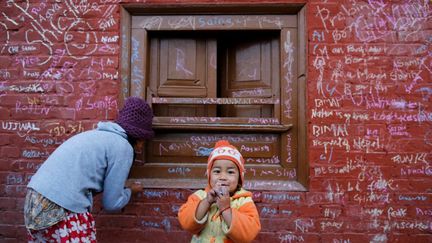 qui, en chaque début d'année, les couvrent de mots écrits à la craie. Rite initiatique pour les plus jeunes: ils prennent ce jour-là leur première leçon de lecture et d'écriture sous les auspices de la déesse du savoir Saraswati. Grâce à elle, croit-on au Népal, les futurs élèves feront tous d'excellentes études.  (NAVESH CHITRAKAR / REUTERS)