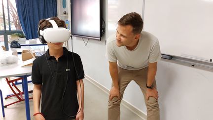 Sébastien Maire, professeur d’EPS, avec Sandro, élève de 6e qui teste le casque de réalité virtuelle. (SOLENNE LE HEN/ RADIO FRANCE)