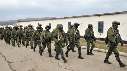 Des hommes arm&eacute;s, sans insigne, bloquent l'acc&egrave;s de la base des gardes-c&ocirc;tes ukrainiens, &agrave; Perevalne, pr&egrave;s de Simferopol, en Crim&eacute;e (Ukraine), le 2 mars 2014. (GENYA SAVILOV / AFP)