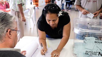 Une femme vote pendant le deuxième referendum sur l'indépendance de la Nouvelle-Calédonie en octobre 2020. (THEO ROUBY / AFP)