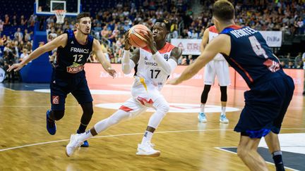 Les Bleus retrouvent l'Allemagne en huitièmes de finale de l'Euro de basket samedi à Istanbul après l'avoir battue en match de préparation fin août à Berlin (85-79). Ci-contre, Dennis Schröder&nbsp;(C) aux prises avec Nando De Colo (G) et Thomas Heurtel (R) le 27 août.&nbsp; (GREGOR FISCHER / DPA)