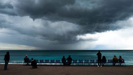 Des passants sous un ciel menaçant, à Nice (Alpes-Maritimes), le 18 avril 2024. (VALERY HACHE / AFP)