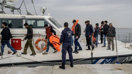 Des réfugiés venus de Syrie et d'Afghanistan débarquent d'un bateau des gardes-côtes grecs, sur l'île de&nbsp;Mytilène (Grèce), le 17 mars 2016. (GUILLAUME PINON / AFP)