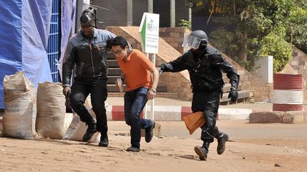 Un otage évacué de l'hôtel Radisson Blu par les forces de sécurité maliennes, à Bamako, le 20 novembre 2015.&nbsp; (HABIBOU KOUYATE / ANADOLU AGENCY / AFP)