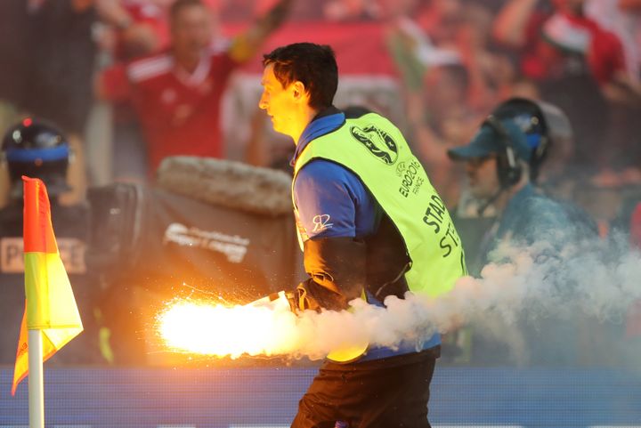 Un stadier éloigne un engin pyrotechnique durant la rencontre entre la Hongrie et l'Islande, samedi 18 juin 2016 à Marseille (Bouches-du-Rhône). (FOTO OLIMPIK / NURPHOTO / AFP)