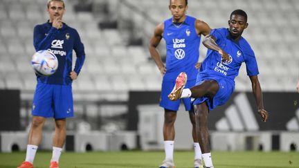 Antoine Griezmann et Jules Koundé regardent Ousmane Dembélé tenter un tir à l'entraînement, le 20 novembre 2022, au stade Jassim-bin-Hamad de Doha. (FRANCK FIFE / AFP)